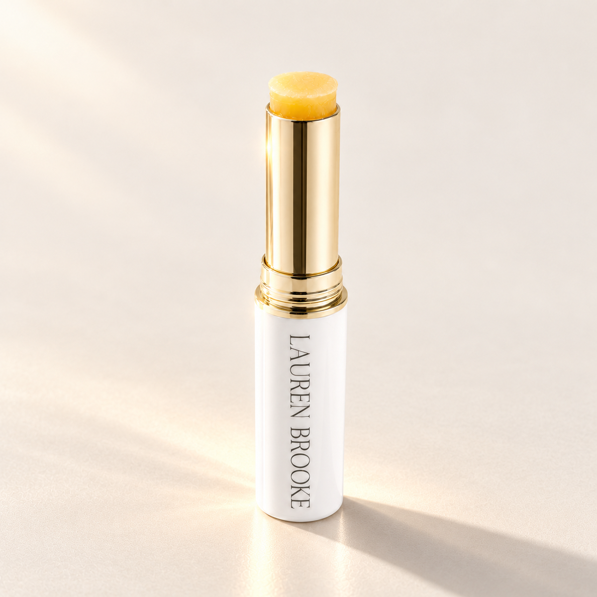 Lauren Brooke Eye Firming Crème stick in a white case with a gold barrel