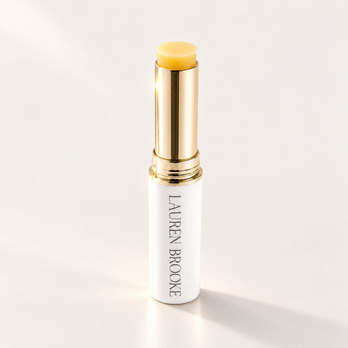 Lauren Brooke Eye Firming Crème stick in a white case with a gold barrel