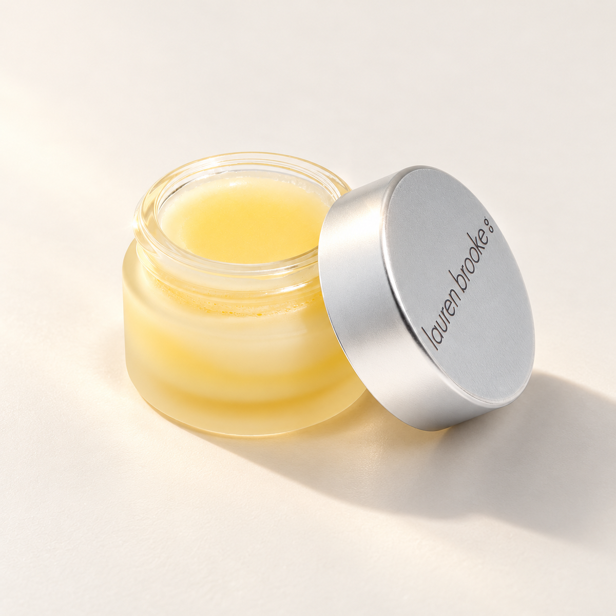Lauren Brooke Eye Makeup Remover balm in an open frosted jar with a silver lid