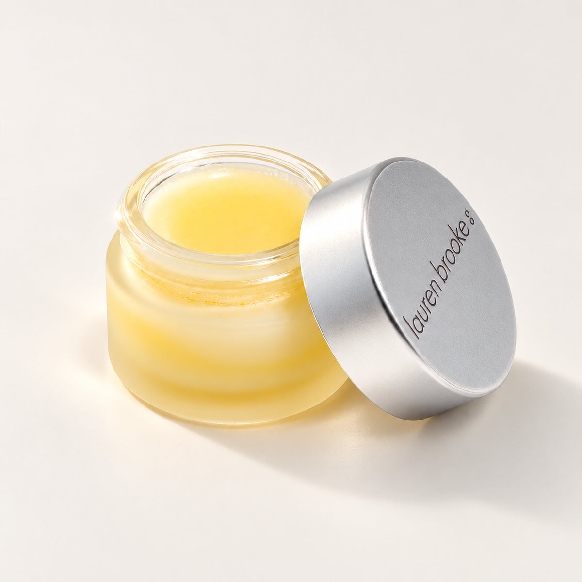 Lauren Brooke Eye Makeup Remover balm in an open frosted jar with a silver lid