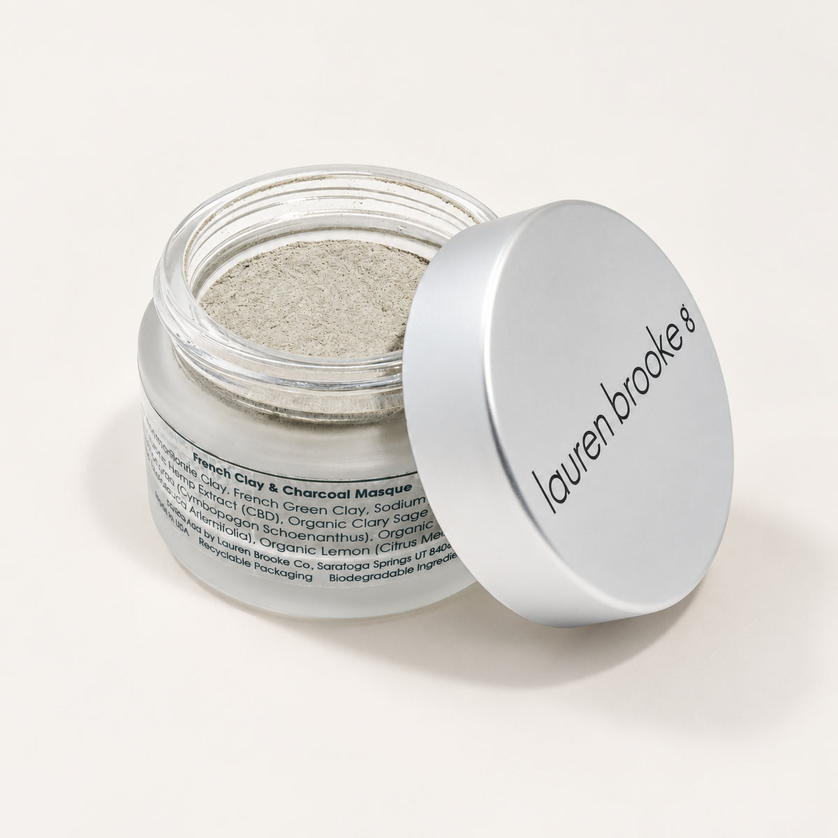 Lauren Brooke French Clay & Charcoal Masque powder in an open frosted jar with a silver lid