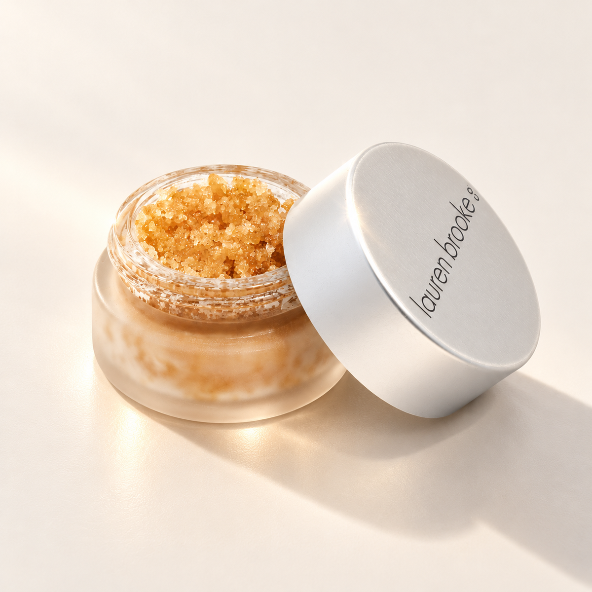 Lauren Brooke Organic Sweet Chai Lip Scrub in an open frosted jar with its lid beside it