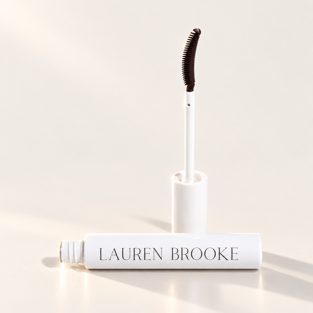 Lauren Brooke Brown tinted eyelash serum with open white tube and applicator